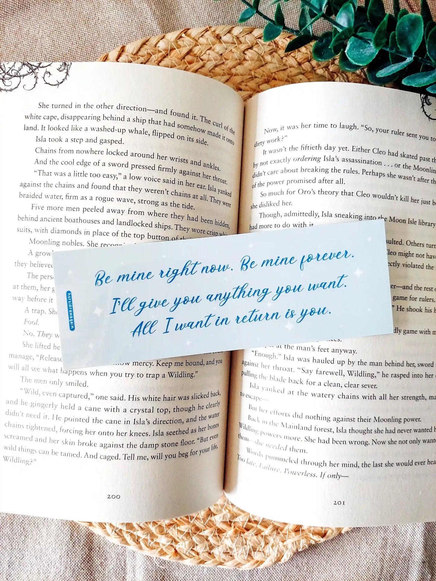 Bookmark inspired by Bridgerton featuring the quote "Be mine right now. Be mine forever. I'll give you anything you want. All I want in return is you", displayed on an open book over a woven mat with decorative plants.