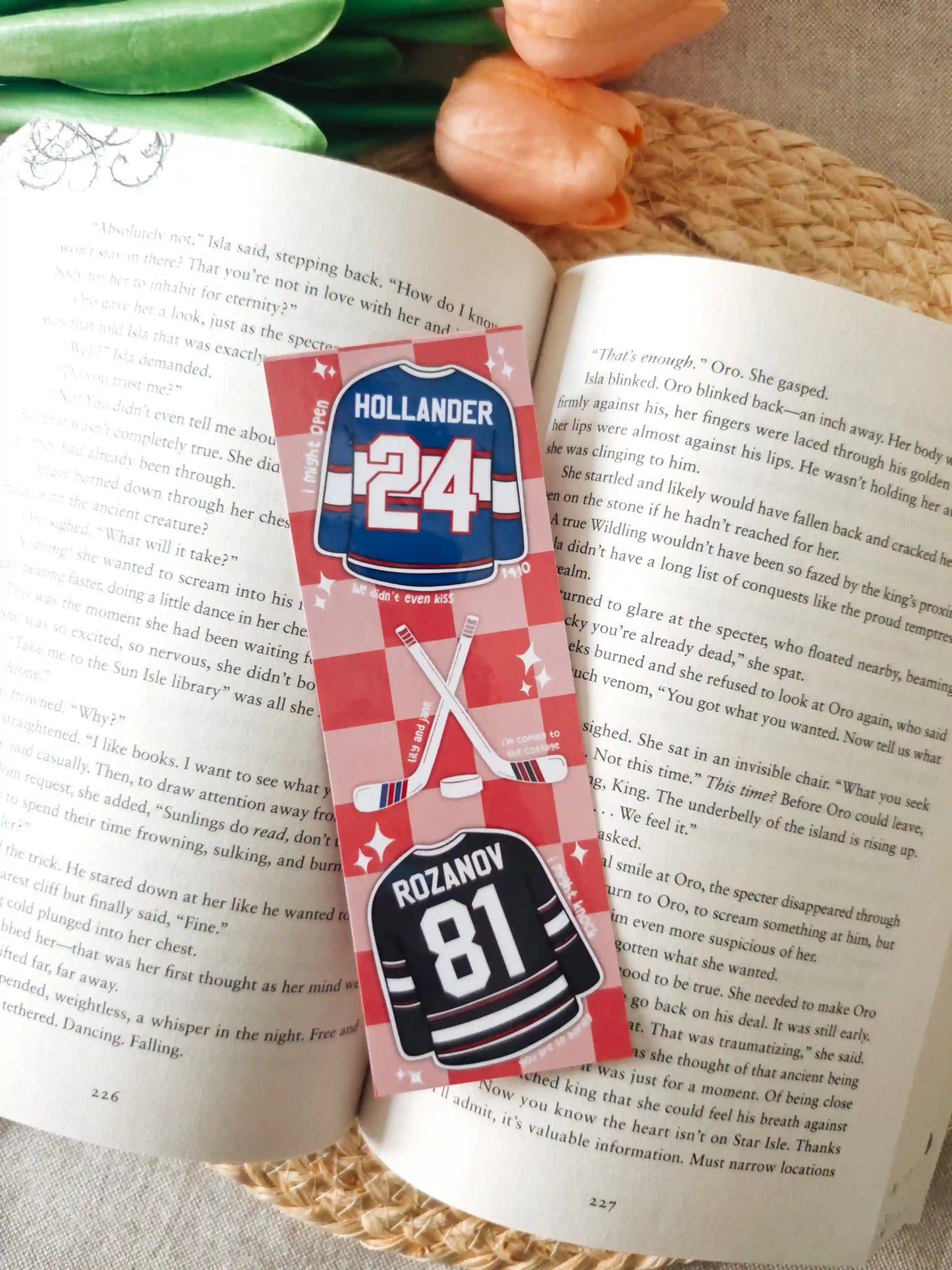 Glossy laminated bookmark featuring Hollander #24 blue jersey and Rozanov #81 black jersey with crossed hockey sticks, a puck and quotes scattered on a red checkered background.
