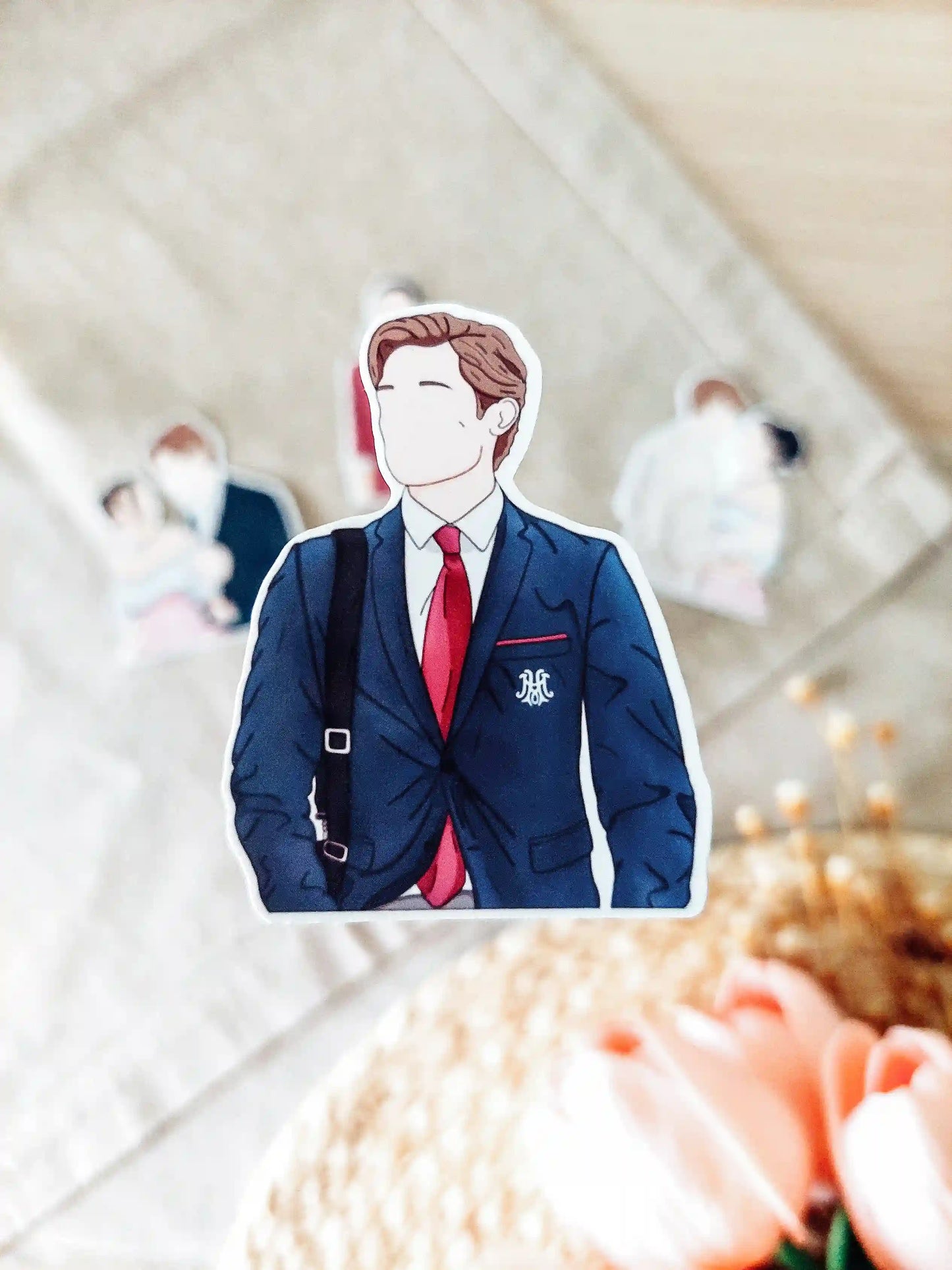 Close up photo of a vinyl sticker inspired by Maxton Hall, featuring James Beaufort in his school outfit.