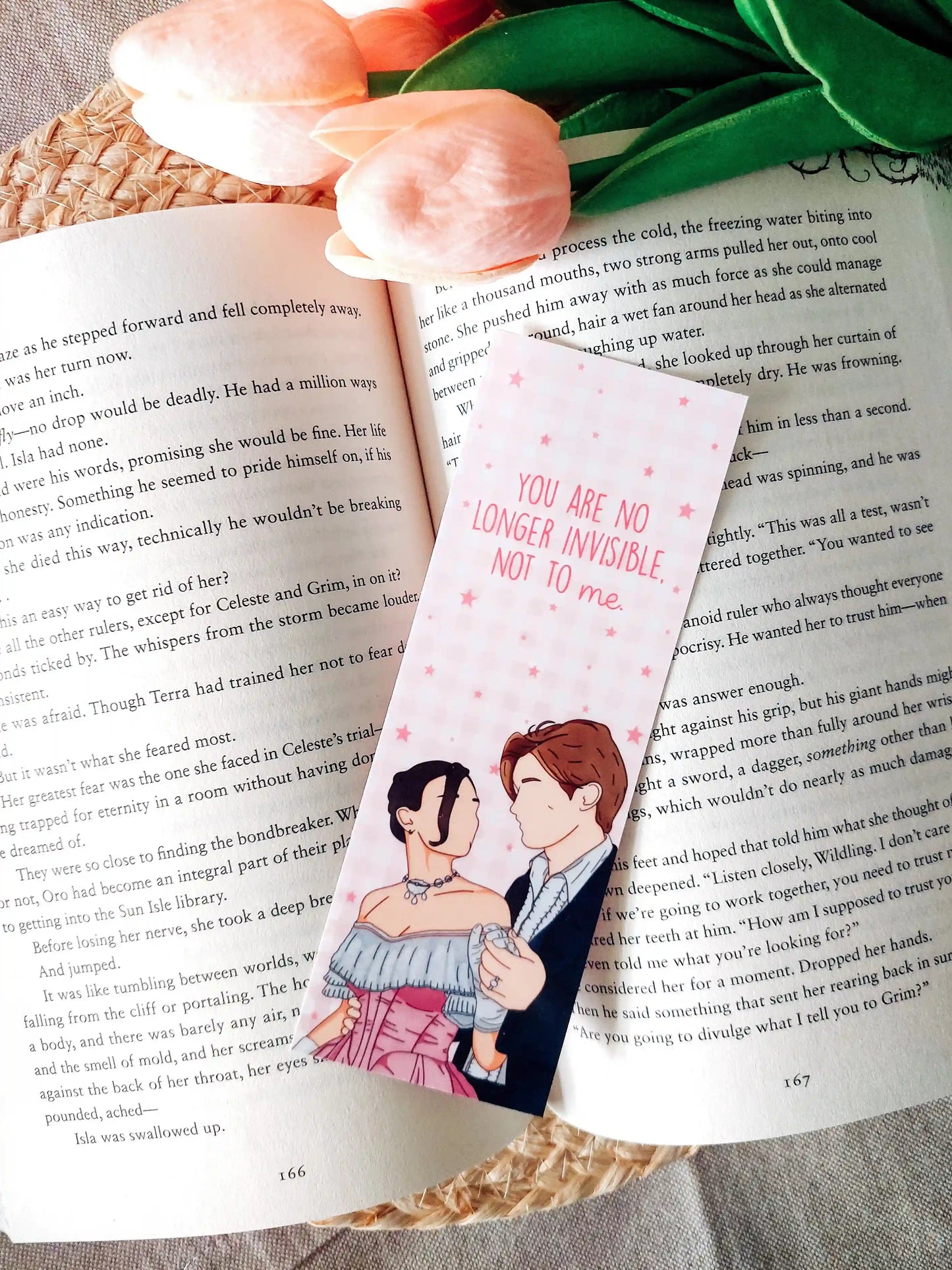 Bookmark inspired by Maxton Hall featuring an illustration of Ruby and James, with the quote "You are no longer invisible, not to me." printed on a pink gingham background, resting on an open book