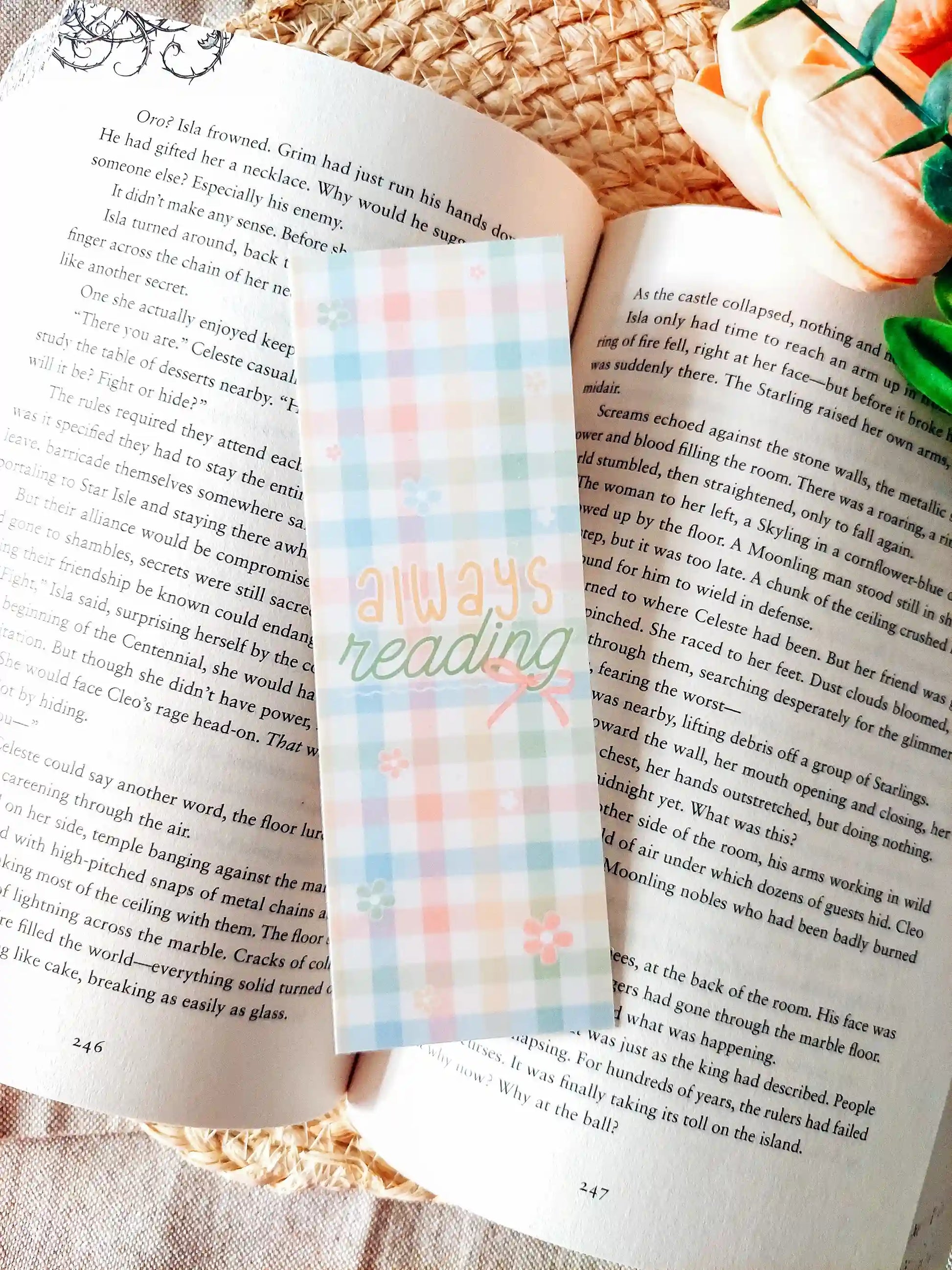 "Always Reading" bookmark placed on an open book, featuring a colourful pastel gingham pattern with small flowers and a bow.