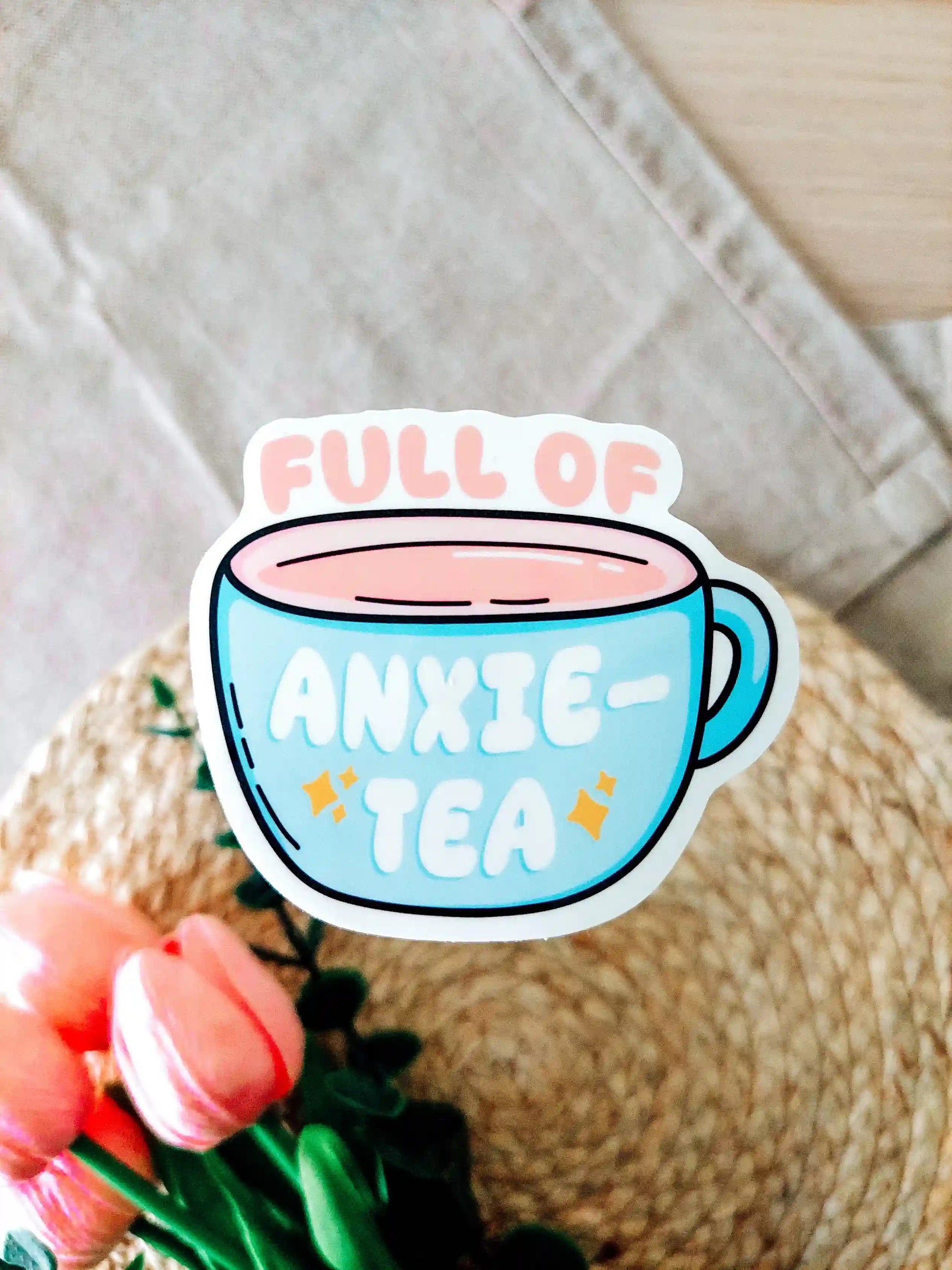 Vinyl sticker of a tea cup design with the text "Full of Anxie-Tea" on a textured surface. 