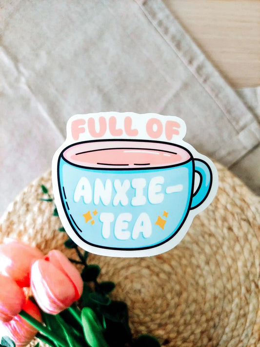 Vinyl sticker of a tea cup design with the text "Full of Anxie-Tea" on a textured surface. 
