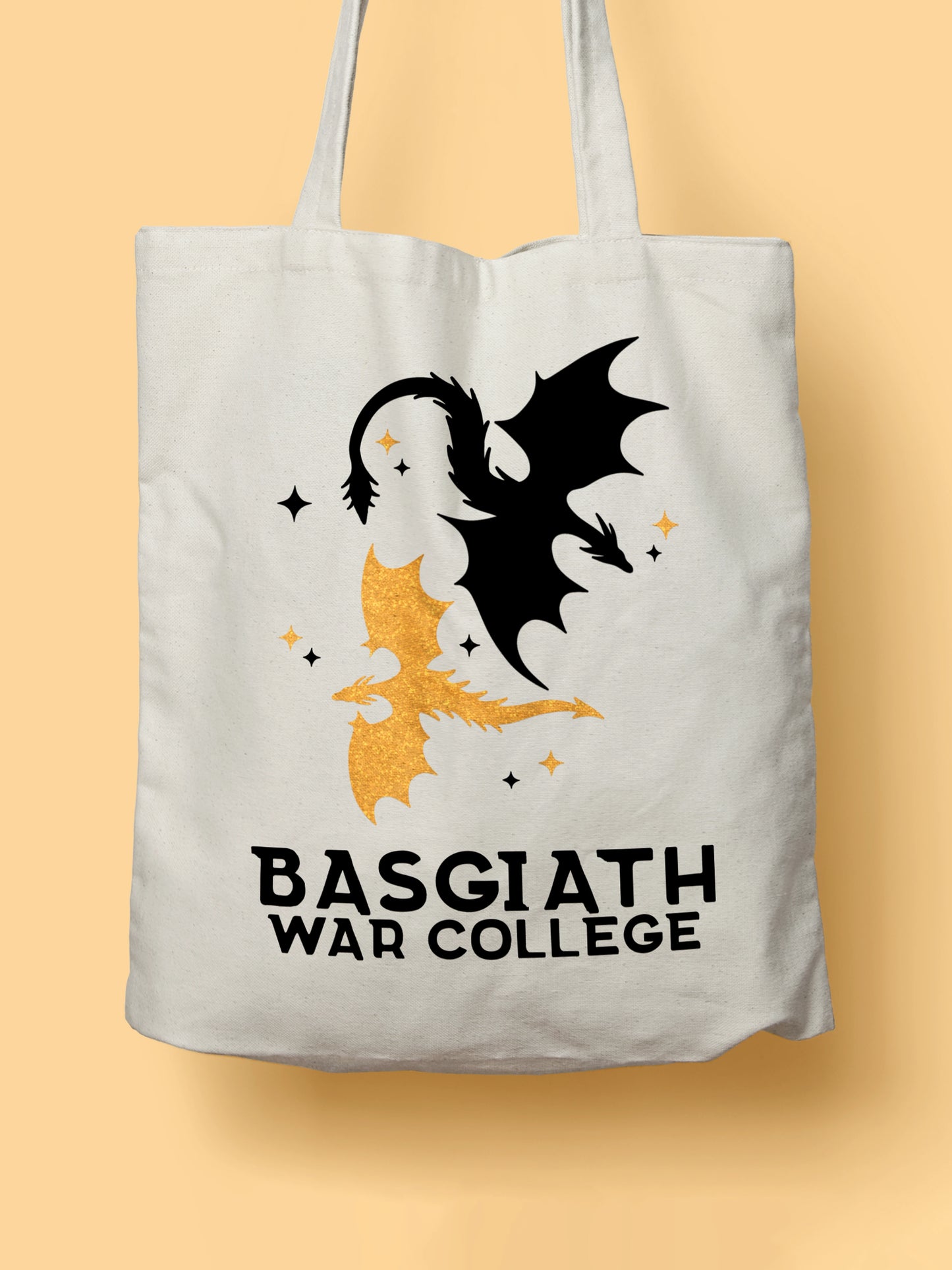 Cotton canvas tote bag featuring a black and a golden dragon illustration with the text “Basgiath War College”, photographed on a yellow background.
