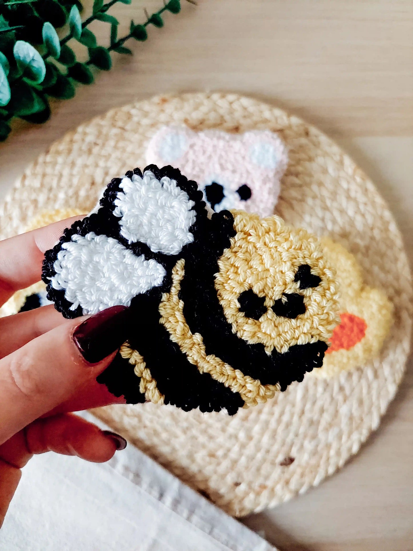 Handmade punch needle coaster, featuring a cute yellow and black bumblebee design with white wings.