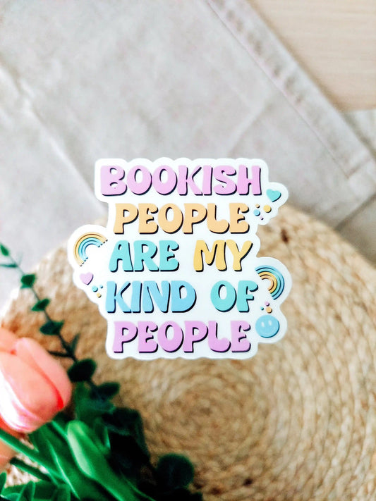 Colorful pastel vinyl sticker "Bookish people are my kind of people" shown on a textured woven surface.