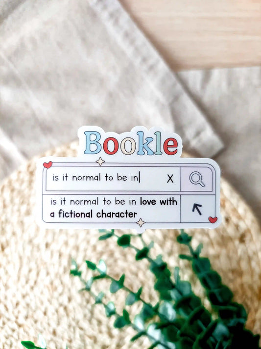 Vinyl sticker designed like a search bar with the text "is it normal to be in love with a fictional character", photographed on a woven background.