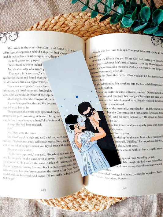 Bookmark inspired by Bridgerton featuring an illustration of Sophie and Benedict, displayed on an open book over a woven mat with decorative plants. 