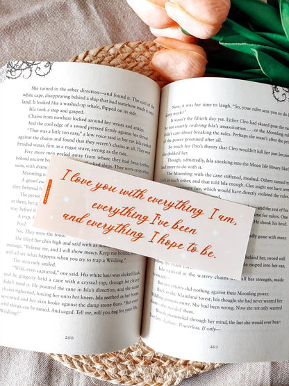 Bookmark inspired by Bridgerton featuring the quote "I love you with everything I am, everything I've been and everything I hope to be", displayed on an open book over a woven mat with decorative plants. 