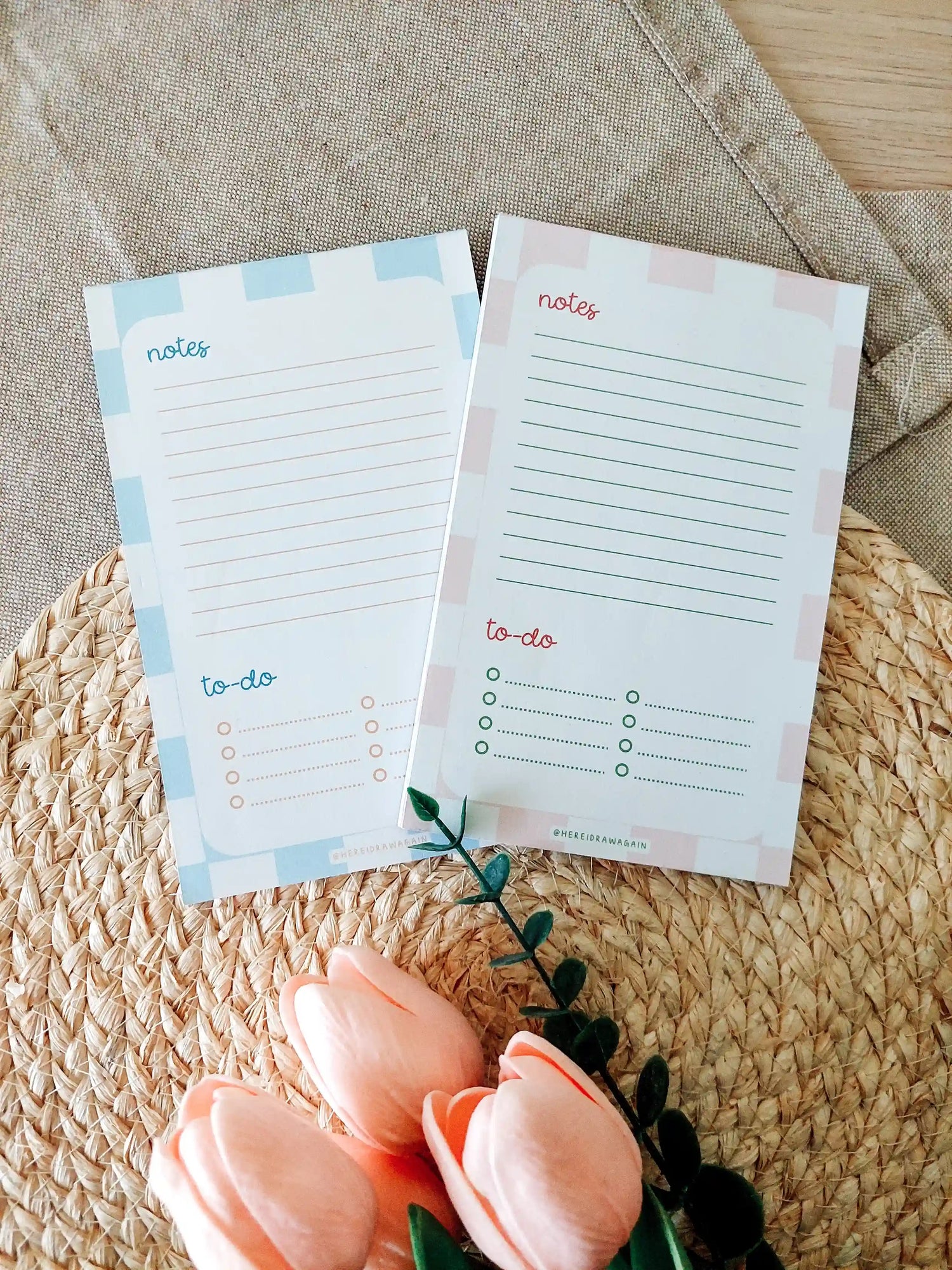 Two notes and to-do notepads, each featuring a lined notes section at the top and a checklist-style to-do section at the bottom, photographed on a woven surface with decorative flowers.