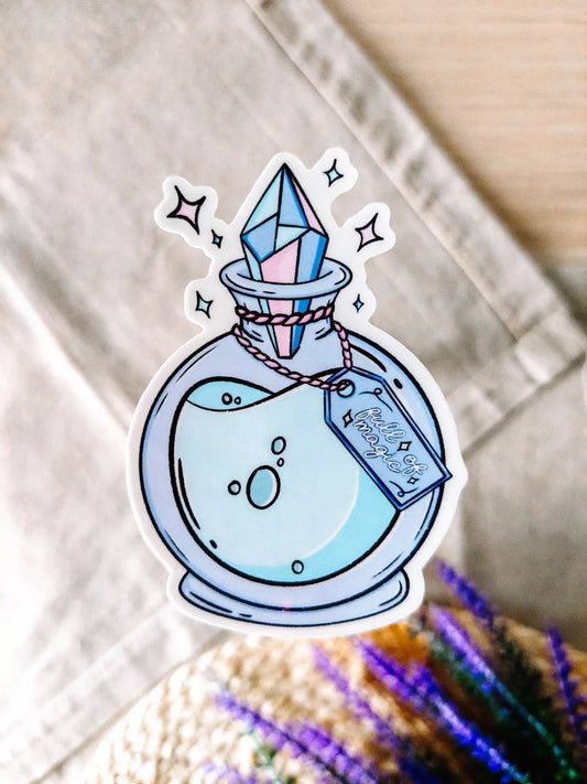 Vinyl sticker of a potion bottle with a crystal stopper and the phrase "Full of Magic", placed on a textured surface.