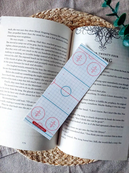 Off Campus inspired bookmark displayed on an open book, featuring  hockey rink patterned background.