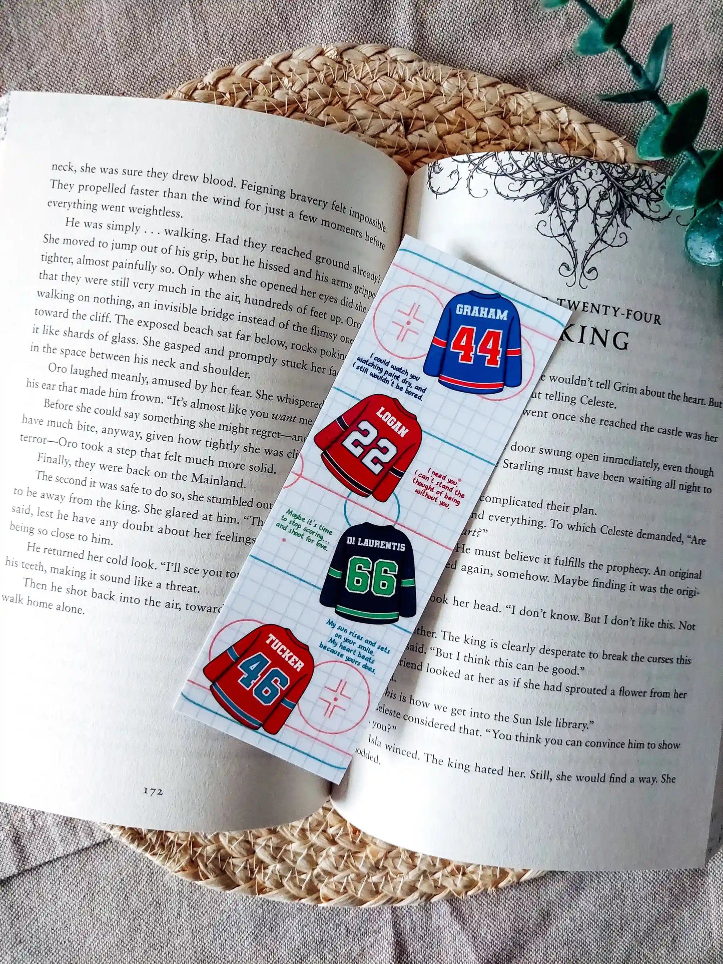 Off Campus inspired bookmark displayed on an open book, featuring "Graham 44", "Logan 22", "Di Laurentis 66" and "Tucker 46" jerseys with their quotes on a hockey rink patterned background.
