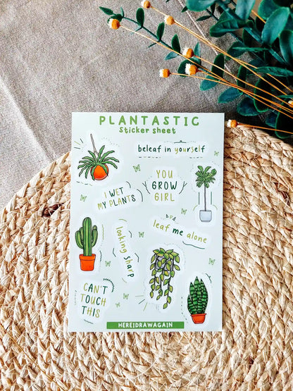Plants themed sticker sheet featuring illustrated houseplants and plant related puns, photographed on a woven mat with decorative flowers.