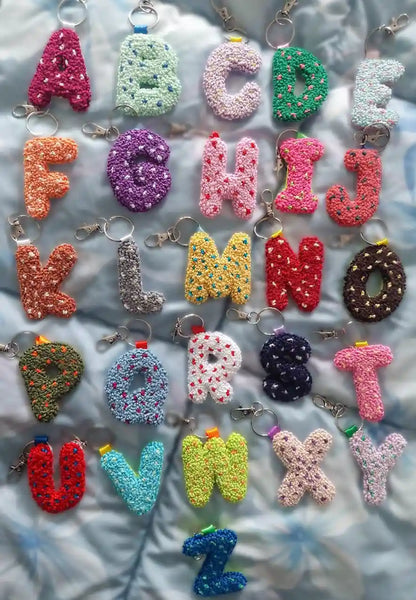 Colorful alphabet keychains on a textured surface