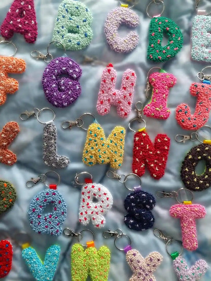 Colorful alphabet keychains on a textured surface