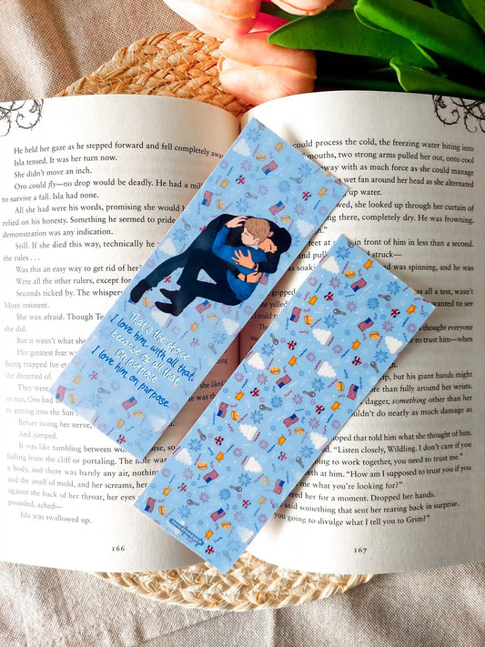 Two-sided Red, White & Royal Blue bookmark showing the front and back: the front features an illustration of Henry and Alex and quote from the book, while the back has a blue patterned design, resting on an open book.