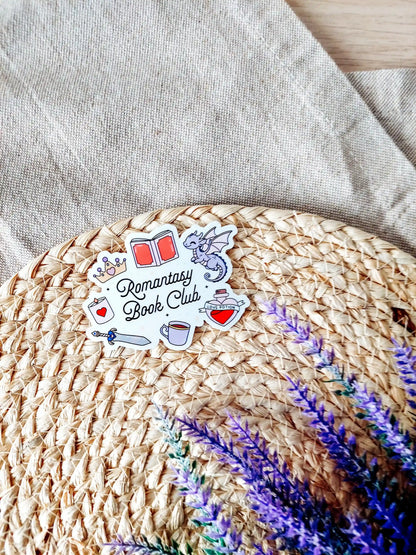 Vinyl sticker with the text "Romantasy Book Club" surrounded by fantasy-themed illustrations including a dragon, crown, sword. 
