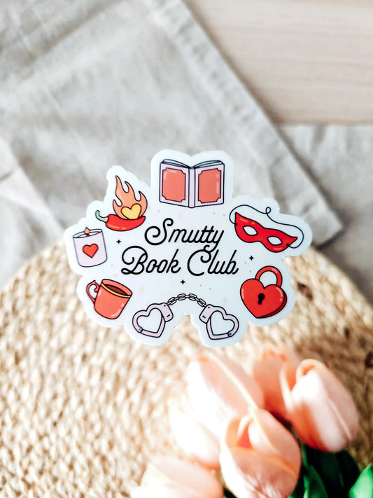 Vinyl sticker with the text "Smutty Book Club" surrounded by romance-themed illustrations including handcuffs, mask, heart lock.