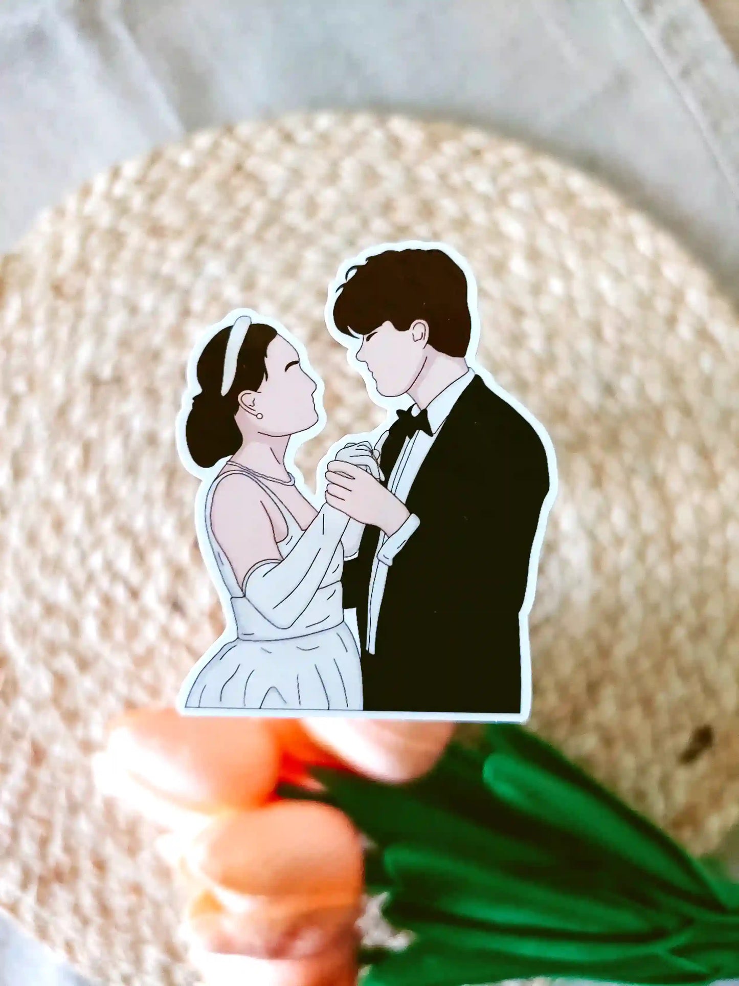 Close up photo of a vinyl sticker inspired by The Summer I Turned Pretty, featuring Belly and Conrad dancing.
