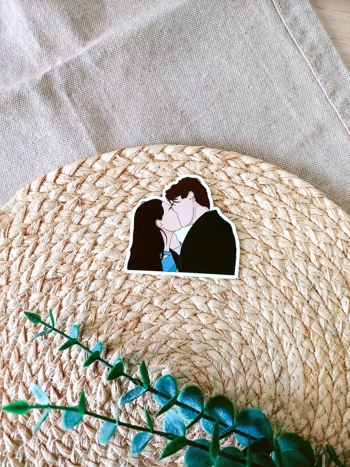 Close up photo of a vinyl sticker inspired by The Summer I Turned Pretty, featuring Belly and Conrad kissing.