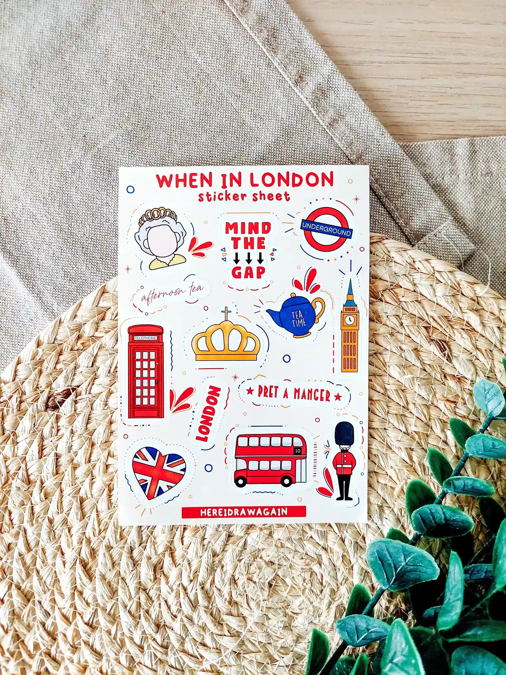 London themed sticker sheet featuring illustrated landmarks, symbols and phrases inspired by London, photographed on a woven mat.